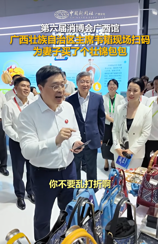 博览会现场，广西壮族自治区主席韦韬为妻子买壮锦包包，“你不要乱打折啊，要正常打折”